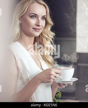 Porträt einer hübschen Blondine Dame Trinken einer Tasse Kaffee Stockfoto