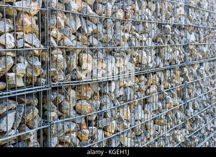 Kabel Gabione rock Zaun. metall Käfig mit Steinen gefüllt. Textur Hintergrund des rock Zaun mit Käfig. Stockfoto