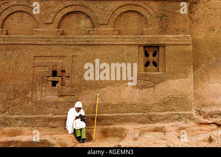LALIBELA, ÄTHIOPIEN – AUGUST 30: Äthiopischer Pilger an der Mauer der alten Kirche in massiven Felsen in Lalibela, Äthiopien, 2013. Stockfoto