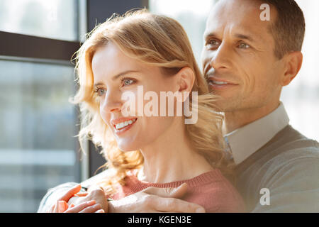 Heiter erfreut Mann seine Freundin umarmen Stockfoto