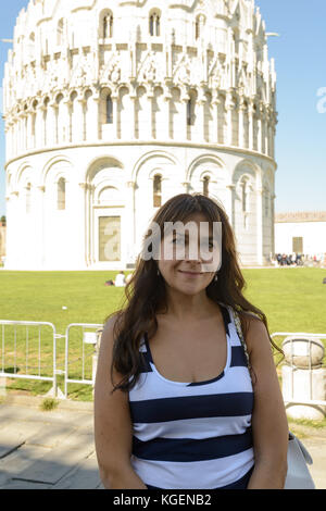 Ein nettes Mädchen in der Piazza dei Miracoli in Pisa posieren, im Hintergrund der Turm und die Kirche Stockfoto