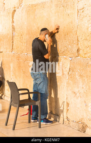 Israel das Heilige Land Jerusalem Altstadt religiöser Jude jüdischer Mann kippur schwarze Schädelkappe betet auf Handy die westliche Klagemauer Kotel Stockfoto