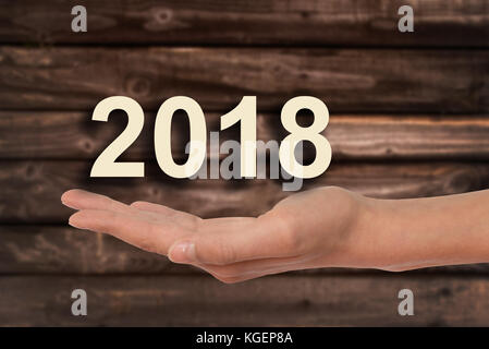 Hand mit 2018 Nummern, Holz Hintergrund Stockfoto