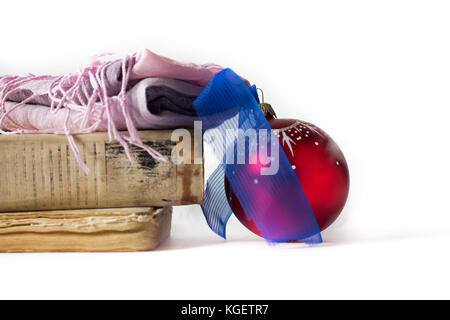 Vintage Books mit weihnachtlichen Schmuck Christbaumkugel auf Holztisch auf weißem Hintergrund Stockfoto
