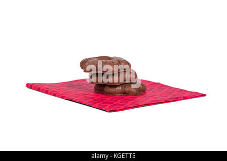 Der detaillierte Blick von oben auf die Schokolade in Herzform Cookie dient auf rosa Serviette, auf weißem Hintergrund. Stockfoto