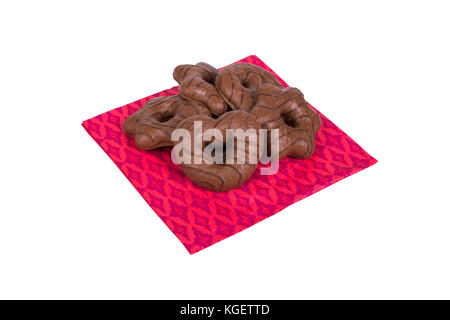 Der detaillierte Blick von oben auf die Schokolade in Herzform Cookie dient auf rosa Serviette, auf weißem Hintergrund. Stockfoto