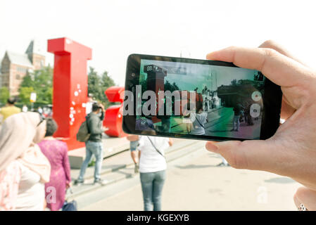 Junge Frau Touristen fotografieren ein Kunstobjekt, iamsterdam. Amsterdam Niederlande september 2017. Stockfoto