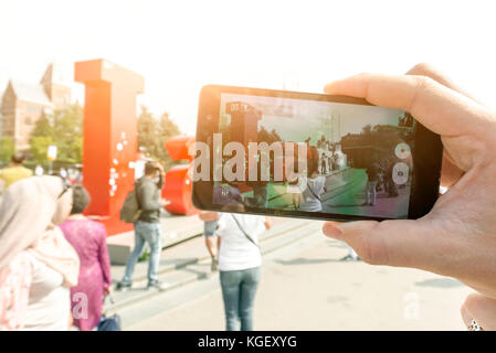 Junge Frau Touristen fotografieren ein Kunstobjekt, iamsterdam. Amsterdam Niederlande september 2017 Stockfoto