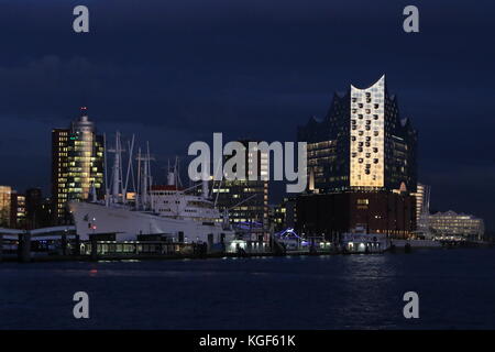 Hamburg, Deutschland. November 2017. Elbphilharmonie glüht im Dunkeln während des dramatischen Sonnenuntergangs im Hamburger Hafen, 06.11.2017. Quelle: T. Brand/Alamy Live News Stockfoto