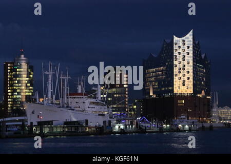 Hamburg, Deutschland. November 2017. Elbphilharmonie glüht im Dunkeln während des dramatischen Sonnenuntergangs im Hamburger Hafen, 06.11.2017. Quelle: T. Brand/Alamy Live News Stockfoto