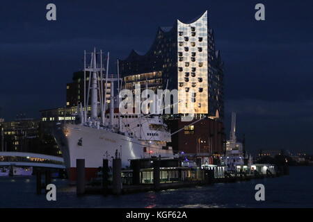 Hamburg, Deutschland. November 2017. Elbphilharmonie glüht im Dunkeln während des dramatischen Sonnenuntergangs im Hamburger Hafen, 06.11.2017. Quelle: T. Brand/Alamy Live News Stockfoto