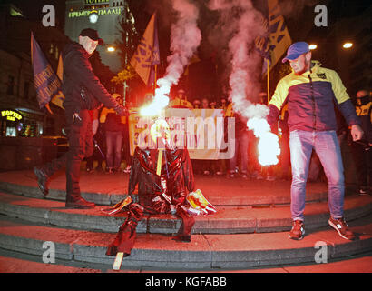 Kiew, Ukraine. November 2017. Mitglieder der rechtsextremen Partei des ukrainischen Nationalkorps verbrannten am 7. November 2017 ein symbolisches Bildnis des ehemaligen Sowjetunion-Gründers Wladimir Lenin in Kiew, während ihres Protests auf dem Sockel des ehemaligen Wladimir-Lenin-Denkmals in Kiew, Ukraine. Aktivisten führten eine Sitzung des symbolischen Exorzismus über die Ukraine durch, indem sie das Bildnis Lenins verbrannten, versuchten, die Überreste der sowjetischen Ideologie zu vertreiben und zu zeigen, dass sie keinen Platz in der Zukunft der Ukraine hat. Die Mitglieder der kommunistischen Partei und ihre Anhänger begehen den 100. Jahrestag des Oktoberbolschewistischen revo Stockfoto