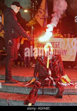 Kiew, Ukraine. November 2017. Mitglieder der rechtsextremen Partei des ukrainischen Nationalkorps verbrannten am 7. November 2017 ein symbolisches Bildnis des ehemaligen Sowjetunion-Gründers Wladimir Lenin in Kiew, während ihres Protests auf dem Sockel des ehemaligen Wladimir-Lenin-Denkmals in Kiew, Ukraine. Aktivisten führten eine Sitzung des symbolischen Exorzismus über die Ukraine durch, indem sie das Bildnis Lenins verbrannten, versuchten, die Überreste der sowjetischen Ideologie zu vertreiben und zu zeigen, dass sie keinen Platz in der Zukunft der Ukraine hat. Die Mitglieder der kommunistischen Partei und ihre Anhänger begehen den 100. Jahrestag des Oktoberbolschewistischen revo Stockfoto