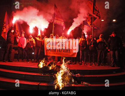 Kiew, Ukraine. 7 Nov, 2017. die Mitglieder der Weit - Ukrainisch - Recht, nationale Korps politische Partei halten Banner lesen wie ''˜ selbst Ändern - Ändern der Ukraine', wie sie ein symbolisches Abbild der ehemaligen Sowjetunion Gründer Vladimir Lenin brennen, während ihren Protest am Sockel des ehemaligen Vladimir Lenin Denkmal, in Kiew, Ukraine, das am 7. November 2017. Die Aktivisten eine Sitzung der symbolischen Exorzismus in der Ukraine durchgeführt durch das Verbrennen des Bildnis Lenins, die versuchen, die Reste der sowjetischen Ideologie zu vertreiben, und um zu zeigen, dass es keinen Platz in der Zukunft der Ukraine. die Mitglieder der Kommunistischen Partei und der Stockfoto