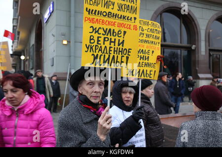 Moskau, Moskau, Russland. November 2017. Eine Frau hält ein Schild hoch und beschwert sich, dass ihre Wohnung von den Behörden gestohlen wurde. Tausende marschierten zum Revolutionsplatz im Zentrum von Moskau, um den 100. Jahrestag der Russischen Revolution zu gedenken. Viele trugen Porträts von Lenin, Stalin und Flaggen mit dem Wappen der Sowjetunion. An dem marsch nahmen auch Menschen aus mehreren Ländern Teil, darunter China, Italien, Venezuela, Brasilien und Kuba. Quelle: Nicholas Muller/SOPA/ZUMA Wire/Alamy Live News Stockfoto