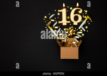 Nummer 16 gold Feier Kerze und Geschenkbox Hintergrund Stockfoto