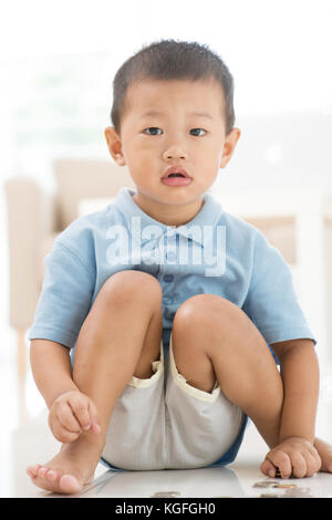 Asiatische Junge speichern Münzen zu Hause. Kind Zukunft Bildungsfonds Konzept. Stockfoto