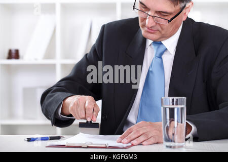 Senior Geschäftsmann konzentrieren sich auf Stempeln Dokument, Vertrag genehmigen Stockfoto