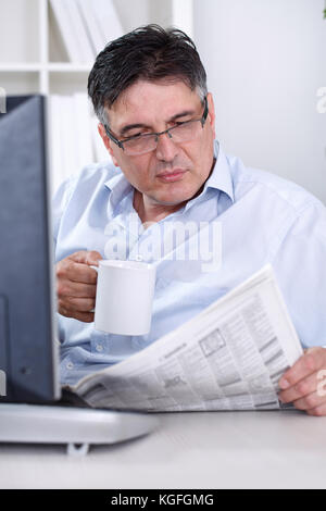 Senior Geschäftsmann die Pause im Büro, lesen Zeitung, Kaffee, Stockfoto