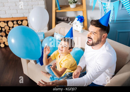 Gerne Vater und Sohn spielen mit Ballons am Geburtstag Stockfoto