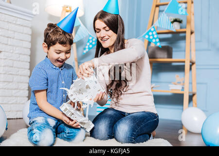 Fröhliche Mutter und Sohn spielen mit Spielzeug Roboter Stockfoto