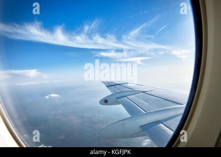 Auf der Suche durch das Fenster Flugzeuge während des Fluges in Flügel mit einem schönen blauen Himmel Stockfoto