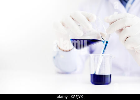 Wissenschaftler und wissenschaftliche Ausrüstung Gießen mischen Reagenzien liqiud Becher, Labor, Forschung Chemie Konzept Stockfoto