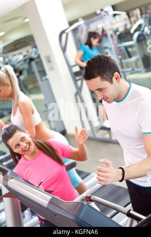 Personal trainer Förderung Mann mit Laufband im Fitnessstudio Stockfoto