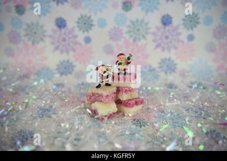 Weihnachten essen Fotografie Bild der altmodische Englisch weiß rosa Kokosnuss Eis Zucker Süßigkeiten mit Glitzer Schneeflocke Hintergrund in Pastellfarben