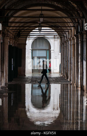 Venedig, Italien. 07. November 2017. Eine Frau geht in ein Portikus während einer Flut am 7. November 2017 in Venedig, Italien. Stockfoto