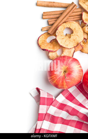 Getrocknete Apfelscheiben und Zimt auf weißem Hintergrund. Stockfoto