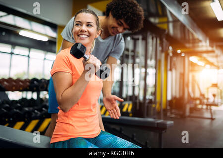 Junge schöne Frau Übungen mit Personal Trainer Stockfoto