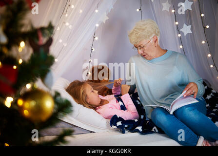 Großmutter lesen einem Märchenbuch Enkelin Stockfoto