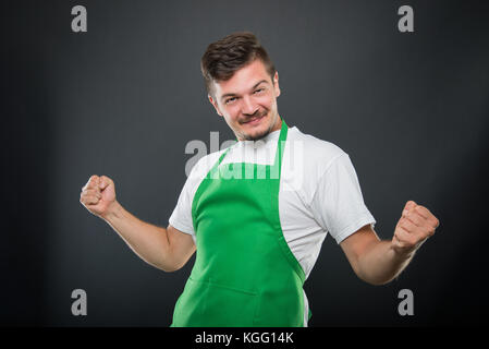 Portrait Supermarkt Arbeitgeber mit Fäusten auf der Suche glücklich wie das Gewinnen Konzept auf schwarzem Hintergrund Stockfoto