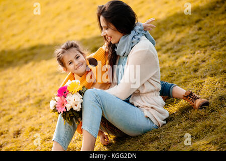 Tochter und Mutter im Park sitzen Stockfoto