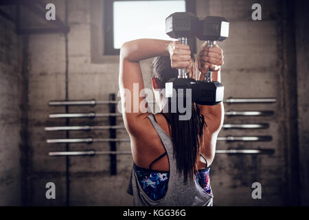Rückansicht eines muskulöse Frau, Übung für Trizeps an der Turnhalle. Stockfoto