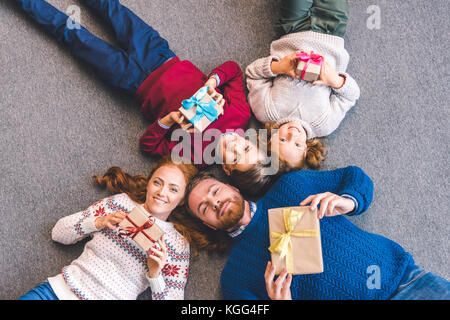 Familie Festlegung auf dem Boden mit Geschenken Stockfoto