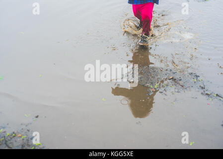 Kind zu Fuß in ein Schlammloch Stockfoto