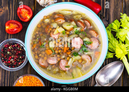 Suppe mit Linsen, Sellerie und Würstchen auf alten Holztisch. studio Foto Stockfoto
