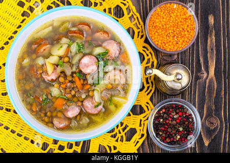 Suppe mit Linsen, Sellerie und Würstchen auf alten Holztisch. studio Foto Stockfoto