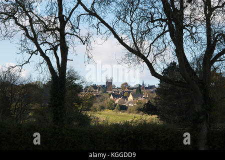 Stow on the Wold im Oktober, umrahmt von Silhouettenbäumen. Stow on the Wold, Cotswolds, Gloucestershire, England. Silhouette Stockfoto