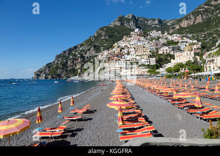 Bunte Stühle und Sonnenschirme an der Spiaggia Grande Beach, in Positano, Italien. Tief blauen Wasser des Tyrrhenischen Meeres. Stockfoto