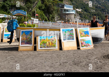 Kunst zum Verkauf gegen ein Boot auf den Strand von Positano, Italien angezeigt. Stockfoto