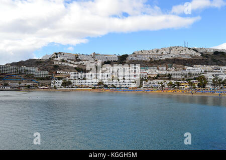 Apartments und Hotels schmücken einen Hügel in Puerto Rico, Gran Canaria, Kanarische Inseln, Spanien. Stockfoto