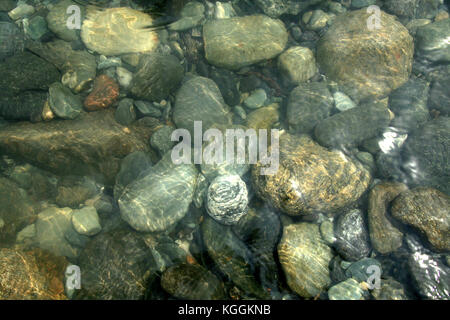Abgerundet Stein Steine in verschiedenen Größen und Maserung unter Wasser unter Wasser Stockfoto