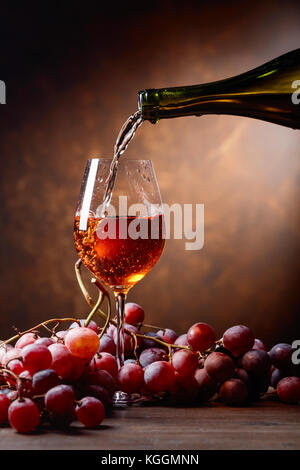 Glas Wein aus der Flasche gegossen wird. Stockfoto