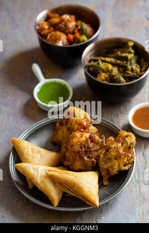 Auswahl indischer Gerichte: Samosas, Zwiebel Bhaji, manchurian Kugeln und Okra Stockfoto