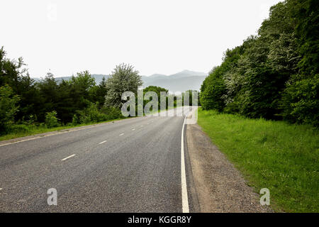 Mountain Road gehen durch die Landschaft in bewölkten Tag. Stockfoto