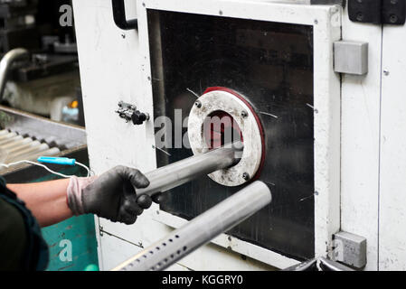 Innerhalb einer Fabrik, Industriearbeiter in Aktion auf Metall Maschine Stockfoto