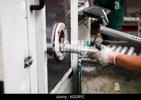 Innerhalb einer Fabrik, Industriearbeiter in Aktion auf Metall Maschine Stockfoto